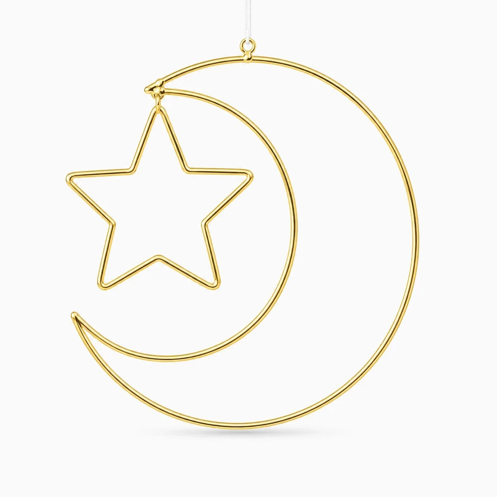 Silhouettes graphiques d'étoiles et lune dorées fixées sur mur blanc pour deco murale épurée