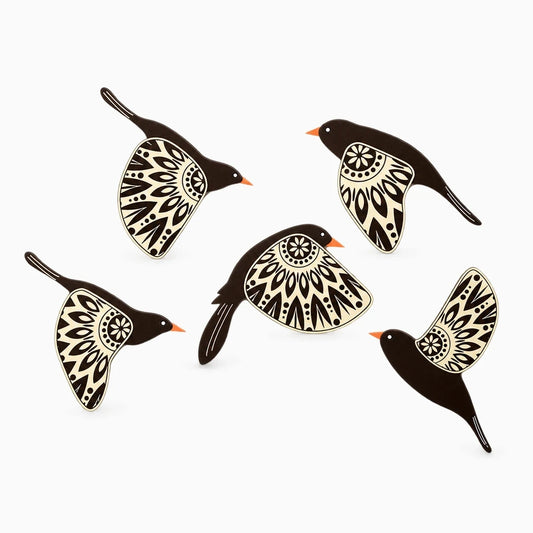 Ensemble de cinq silhouettes d'oiseaux en bois noir disposées sur un mur clair